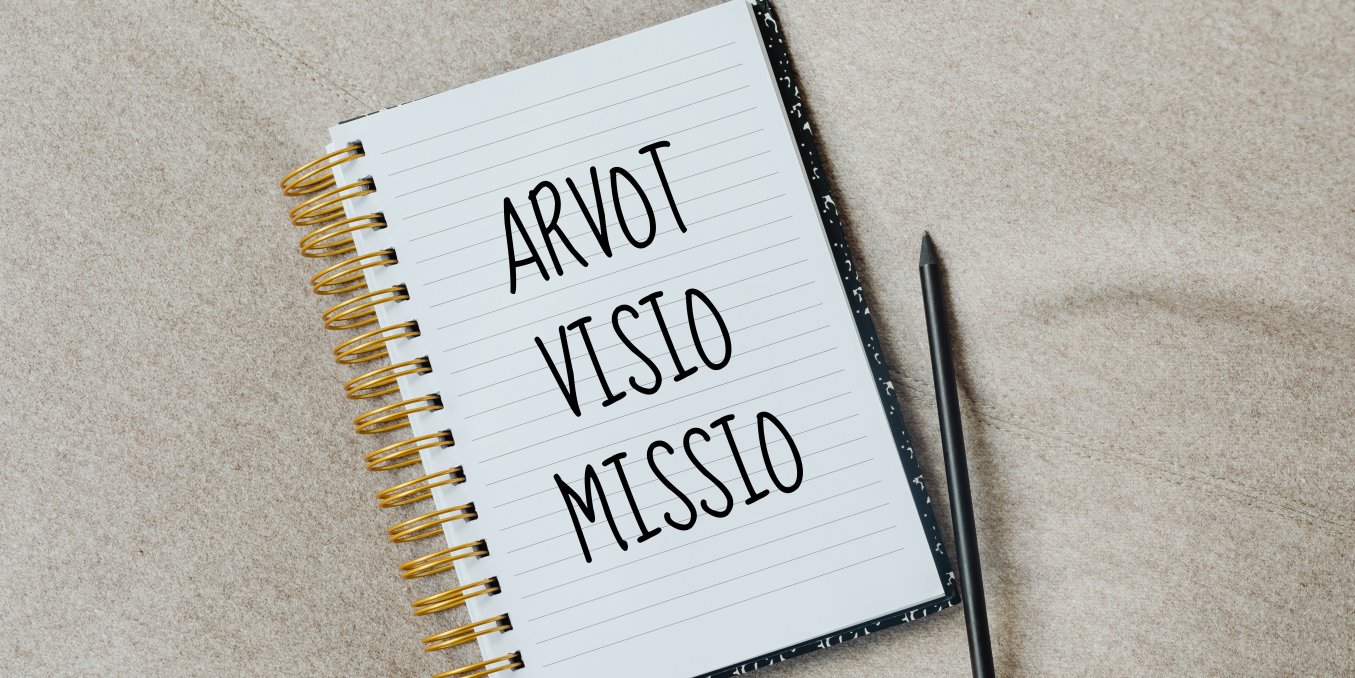 Muistikirja, jonka sivu avattuna ja jossa lukee arvot, visio ja missio. Musta kynä muistikirjan vieressä.